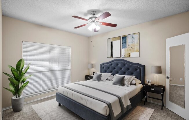 a bedroom with a large bed and a ceiling fan
