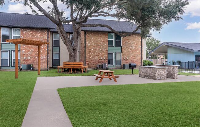 a house with a lawn in front of a brick building