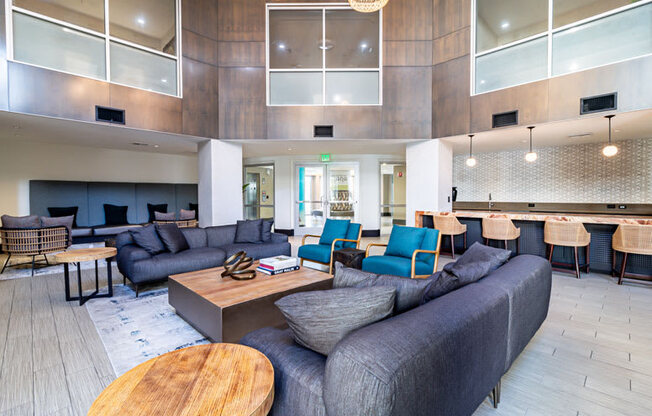 a lobby with couches tables and chairs and a kitchen