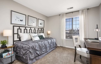 Furnished model bedroom with office desk and golf course view from the oversized bay windows
