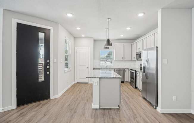 a renovated kitchen with white cabinets and stainless steel appliances