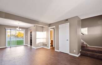 an empty living room with hard wood floors and a staircase