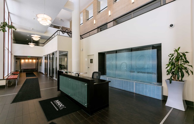 the lobby of a building with a reception desk and a large screen