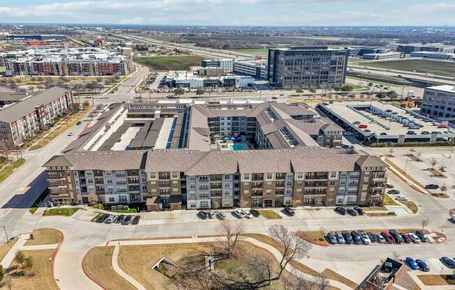 A large apartment complex with a parking lot in front.