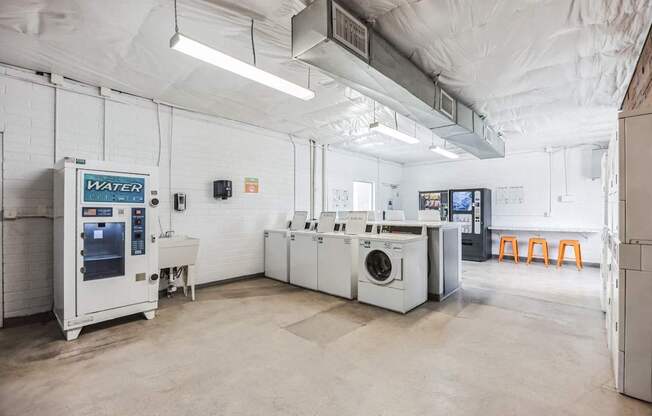 A clean, white industrial room with a water machine and a washing machine.