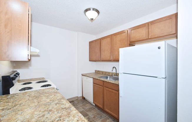 a kitchen with a white refrigerator freezer next to a stove top oven