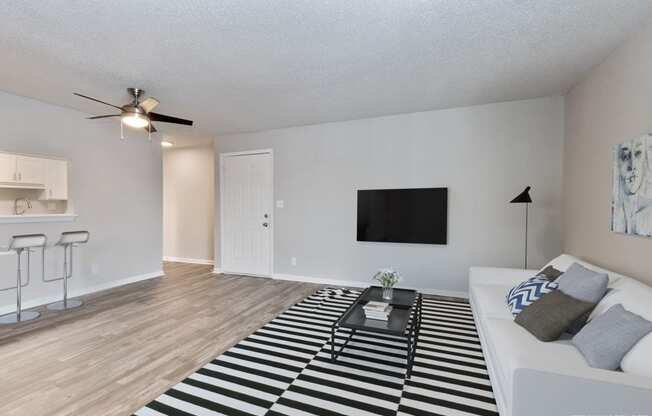 an open living room with a white couch and a black and white rug  at Eastwood Crossings, Kansas City, 64129