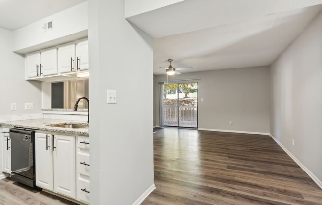 an empty kitchen and living room with a door to a patio