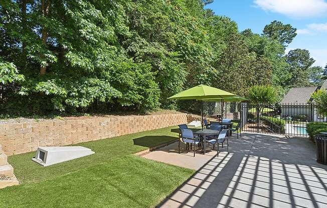 Outdoor Picnic Area with Lounge Furniture and Corn Hole Sets at Retreat at Stonecrest Apartments located in Lithonia, GA.