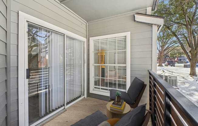 A balcony with a table and chairs is shown.