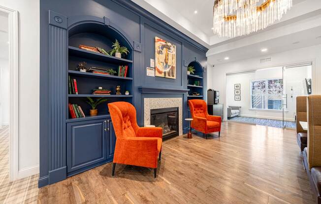 A living room with a fireplace and two orange chairs.