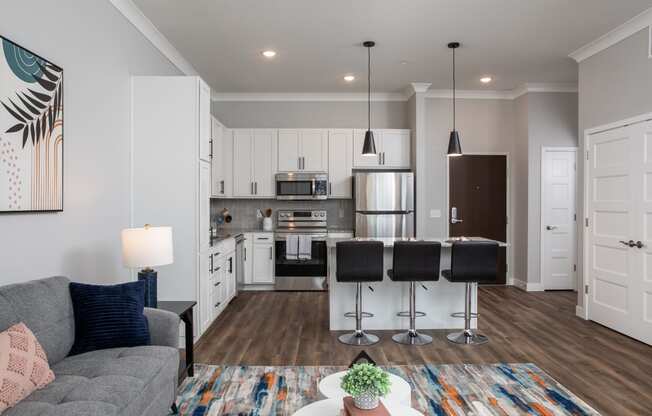 a living room with a kitchen with a bar and a couch at The Edison at Maple Grove, Maple Grove, MN 55129