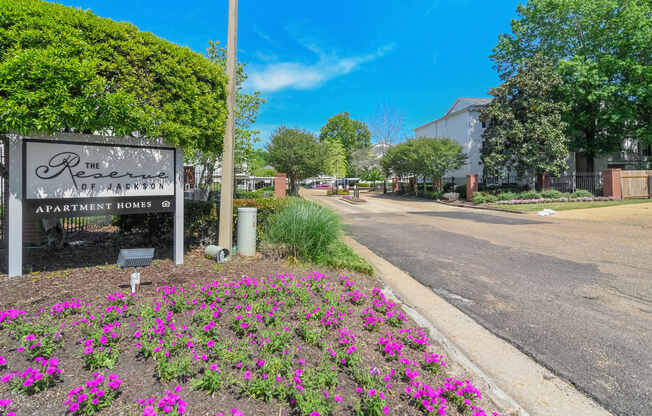 a street with a sign and flowers on the side of a road at Reserve of Jackson Apartment Homes, Mississippi