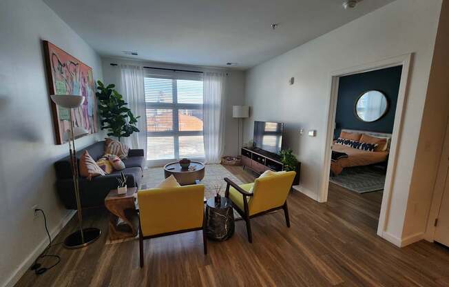 A living room with a yellow chair and a couch.