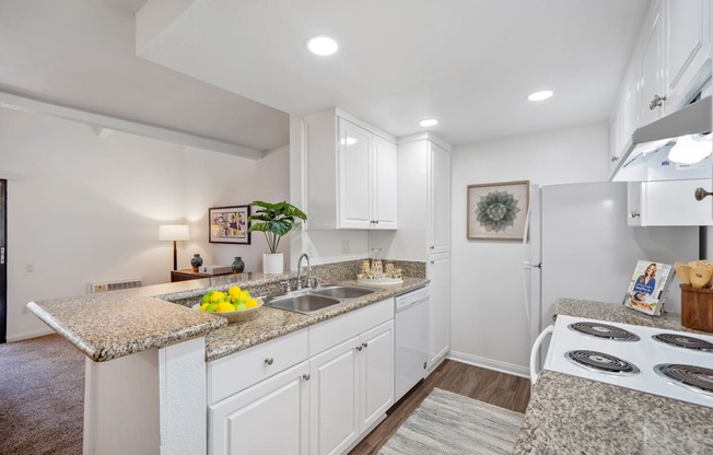 a kitchen with white cabinets and granite countertops