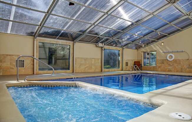 a swimming pool with a glass ceiling and tile floor