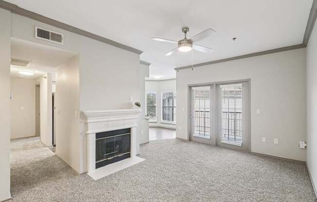 A living room with a fireplace and a ceiling fan.