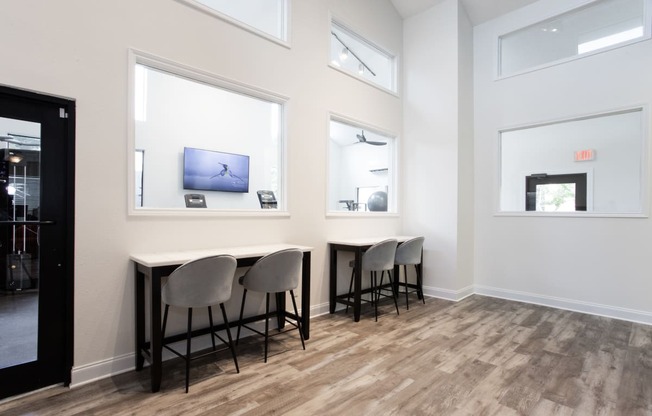 a dining room with three chairs and a table with three windows