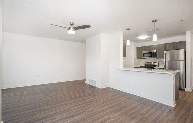 A living room leading to a kitchen with a breakfast bar at Meadowbrooke Apartment Homes in Kentwood, MI 49512