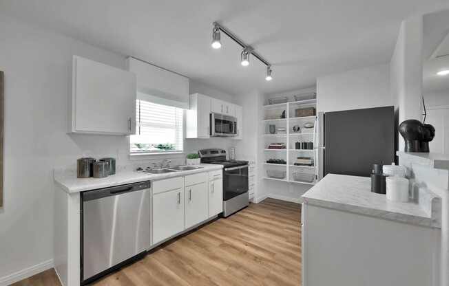 Welcome to Esperanza at Wild Orchid, where modern elegance meets functionality. This stunning kitchen features sleek white cabinetry, stainless steel appliances, and ample storage. Elevate your living experience today—schedule a tour now!