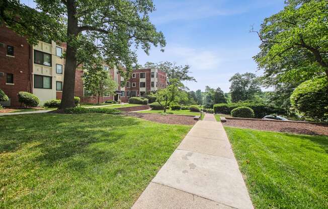 a grassy area with trees and buildings in the background