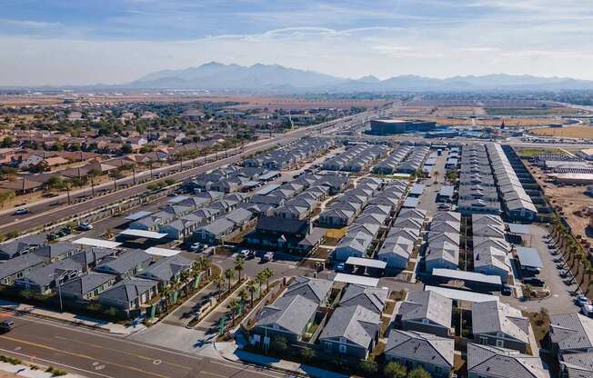 an aerial view of a suburb of houses and an airport with mountains in the background