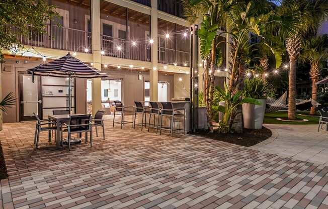 a patio with tables and chairs and a building in the background