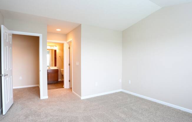 a room with carpet and a door to a bathroom