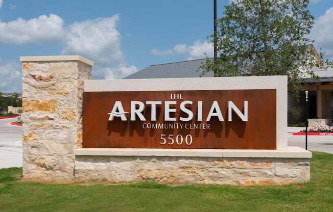 The sign for The Artesian Community Center is brown and white.