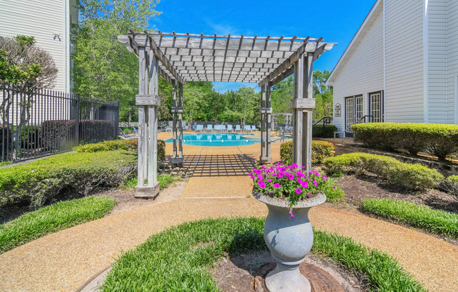 a garden with a vase of flowers in front of a pool at Reserve of Jackson Apartment Homes, Mississippi, 39211