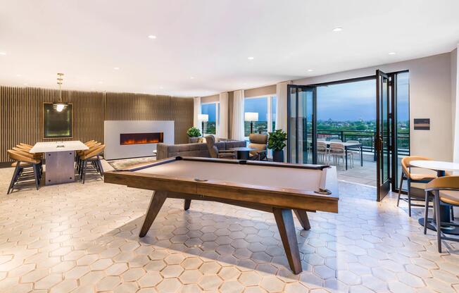 Play, host, or unwind in the rooftop lounge—featuring a fireplace, pool table, and seamless access to panoramic Capitol views on the terrace.