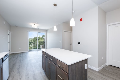 a large kitchen with a white counter top and wooden floors