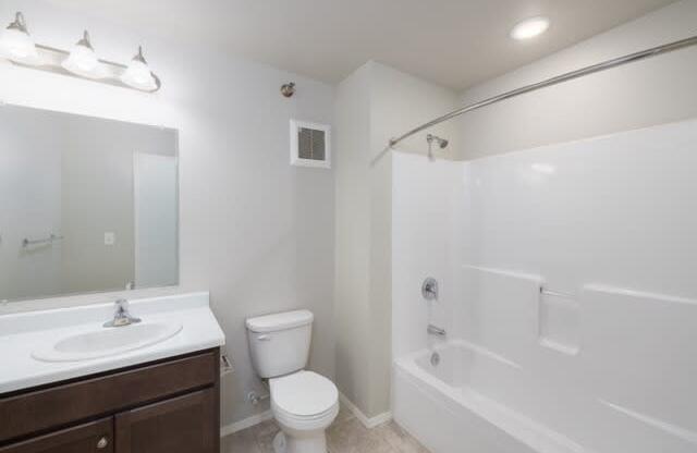 A white bathroom with a toilet, sink, and bathtub.