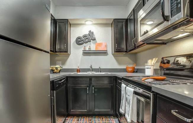Fully equipped kitchen with stainless steel appliances, quartz countertops, and updated cabinets