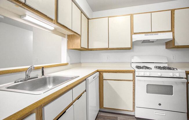 a kitchen with white appliances and wooden cabinets
