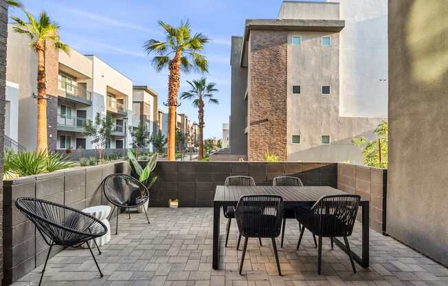 A patio with a table and chairs and a palm tree.