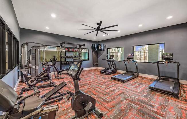 Modern fitness center at Summit on Boulder Apartments equipped with state-of-the-art cardio machines, a variety of free weights, and stylish decor.