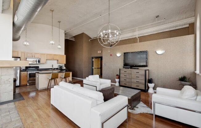 a large living room with white chairs and a table