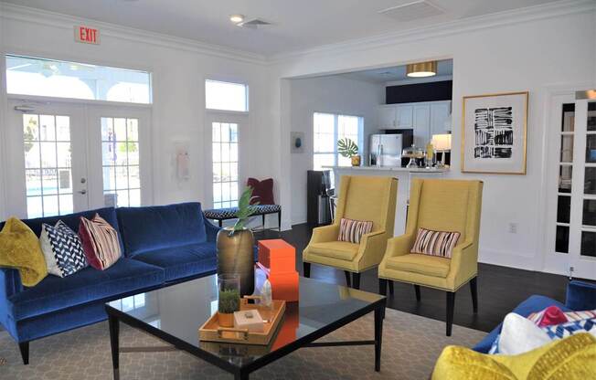 A living room with a blue couch, yellow chairs, and a coffee table.
