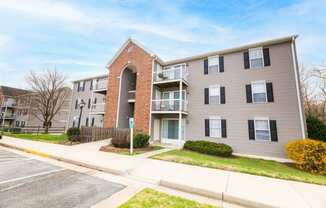a picture of an apartment building with a sidewalk in front of it