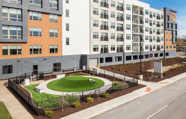 A modern building with a green space in front.