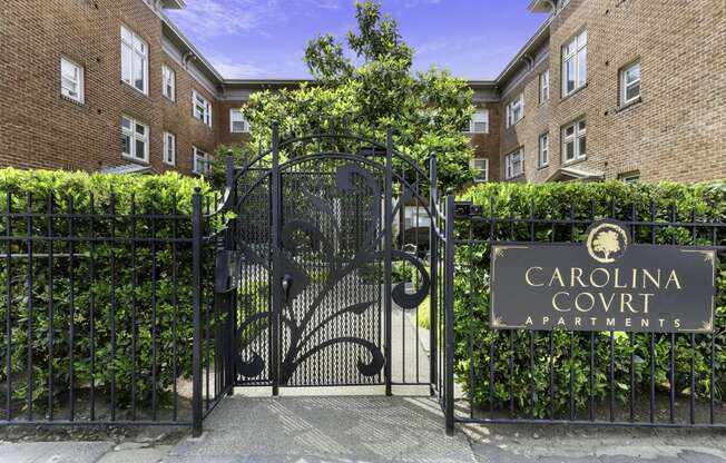 a gate with a sign that reads carolina court apartments