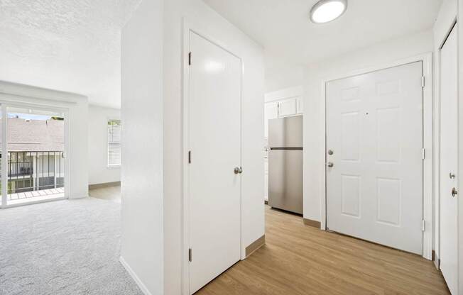 A white door is open to a kitchen area.