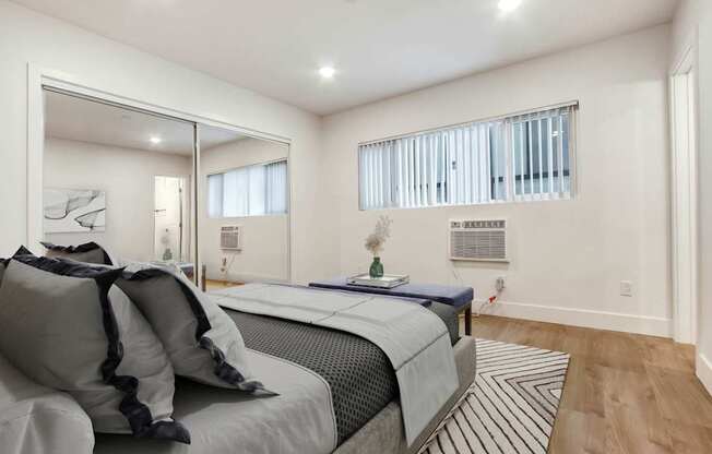 A bedroom with a large bed and a mirror on the wall.