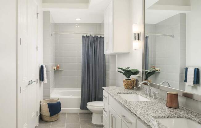A bathroom with a white tub, sink, and toilet.