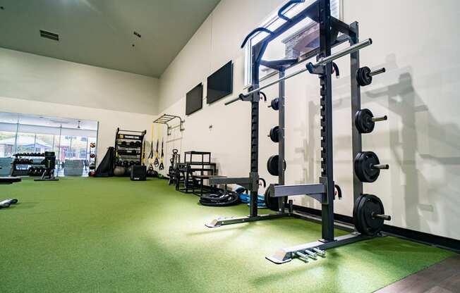 a gym with weights and other equipment on a green floor