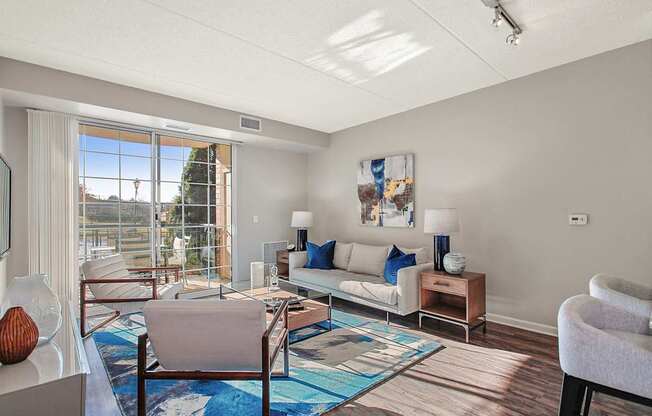 A living room with a couch, chairs, and a rug.