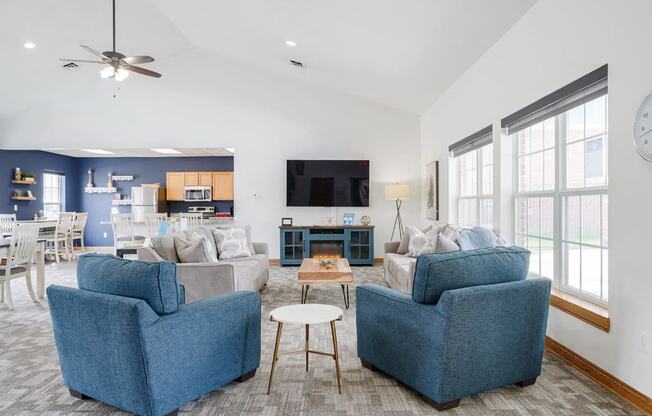 Lounging area with TV on the wall and couches and chairs