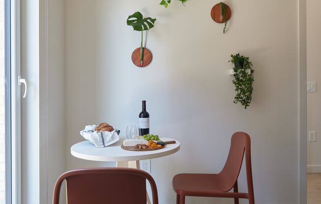 a small table with two chairs and a bottle of wine