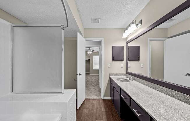 A bathroom with a white tub and sink.